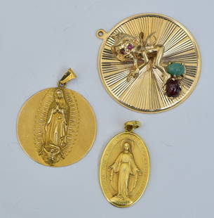 18k and 14k Gold Charms (3): Two 18k gold pendants- Madonna and Christ together with a 14k gold pendant of an elf with ruby eyes standing on garnet and turquoise stones, 1 1/2" long, weight is 18.1 dwt gross