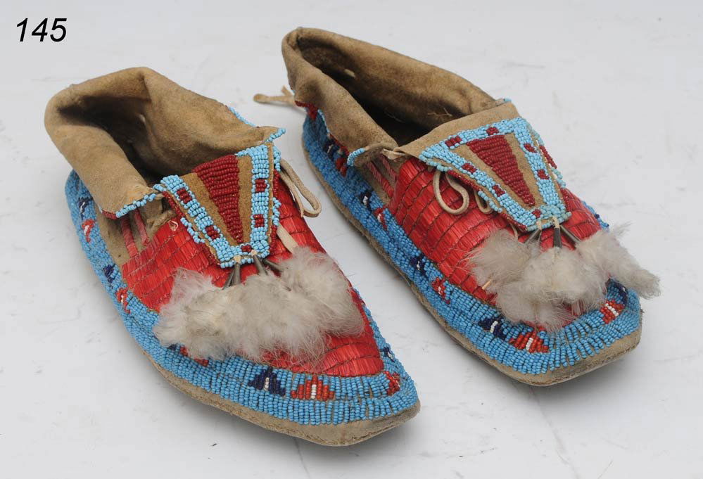 PAIR OF SIOUX QUILLED AND BEADED HIDE MOCCASINS: PAIR OF SIOUX QUILLED AND BEADED HIDE MOCCASINS with tin cone and feather suspensions each 9 3/4" long Shipping Information: Shipping within the Continental USA (excludes insurance):$30. Internationa