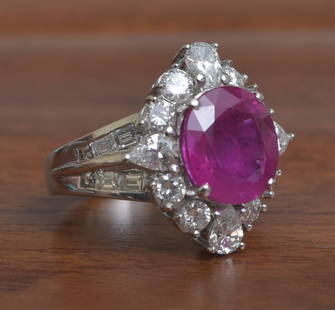 Platinum Ruby and Diamond Ring: Platinum Ruby and Diamond Ring the ruby measuring 11mm x 10mm x 5.2mm depth surrounded by eight round brilliant cut diamonds and four pear shaped diamonds and with twelve baguette diamonds on the shan