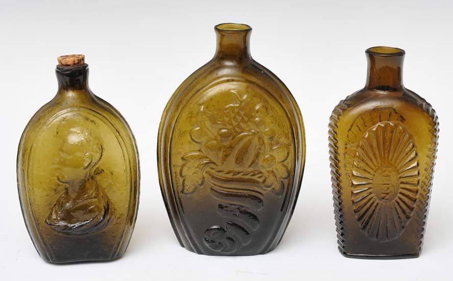 Group of Three Early American Flasks: each olive green largest 7" high estimate 400/600 Shipping available within the Continental USA (excludes insurance) $40. International shippers are responsible for arranging 3rd party shipping.