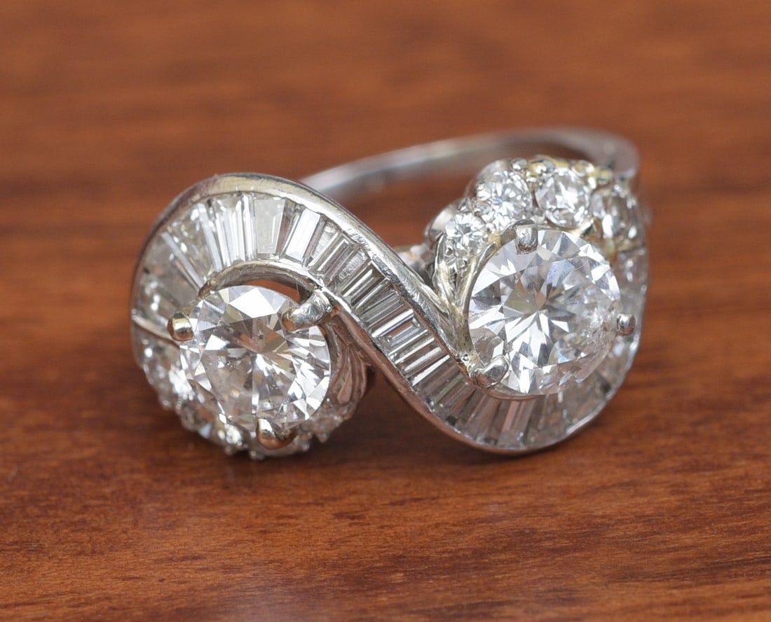 Platinum and Diamond Bypass Ring: Platinum and Diamond Bypass Ring set with two round brilliant diamonds estimated .90 carats each, j-k color and I-1 clarity with additional smaller round brilliant and baguette diamonds in the setting