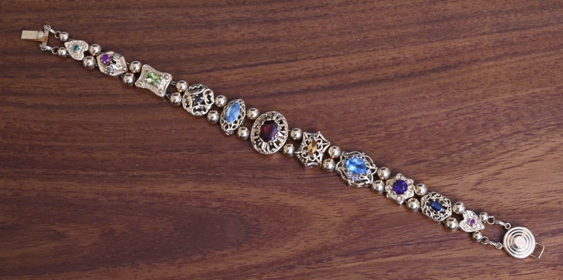 Richard Klein 14k Gold Gemstone 11-Slide Charm Bracelet: Richard Klein 14k Gold Gemstone 11-Slide Charm Bracelet multi gemstone including garnet, blue topaz and amethyst graduated charms 5/8" to 1/4" wide 7" long bracelet, weight is 25.9 grams gross stamped
