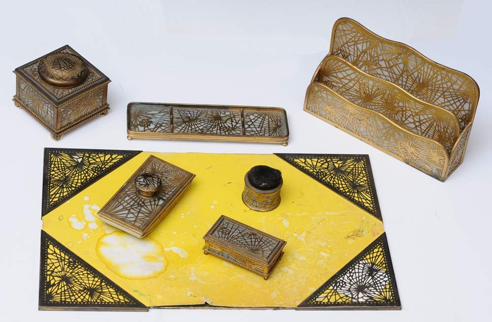 Tiffany Studios Seven Piece Desk Set: Pine Needle Pattern including 10" letter rack, ink stand, pen tray, blotter, stamp box, pen wipe, corners early 20th century estimate 1200/1800 SHIPPING INFORMATION Shipping available within the Conti