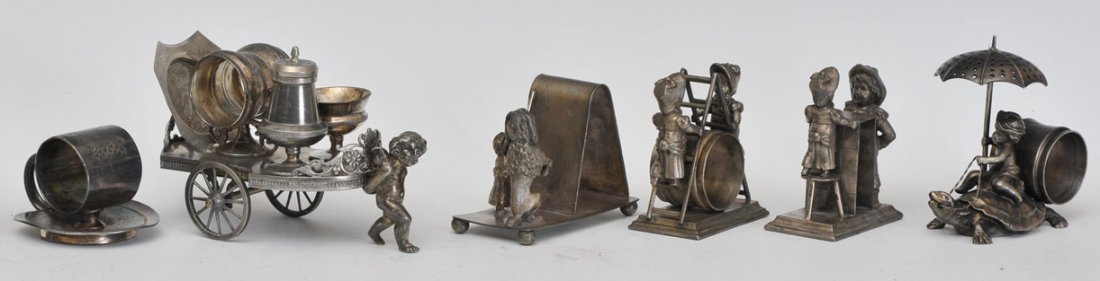 Group of 6 Silverplated Figural Napkin Rings: including cherub and wagon estimate 400/600