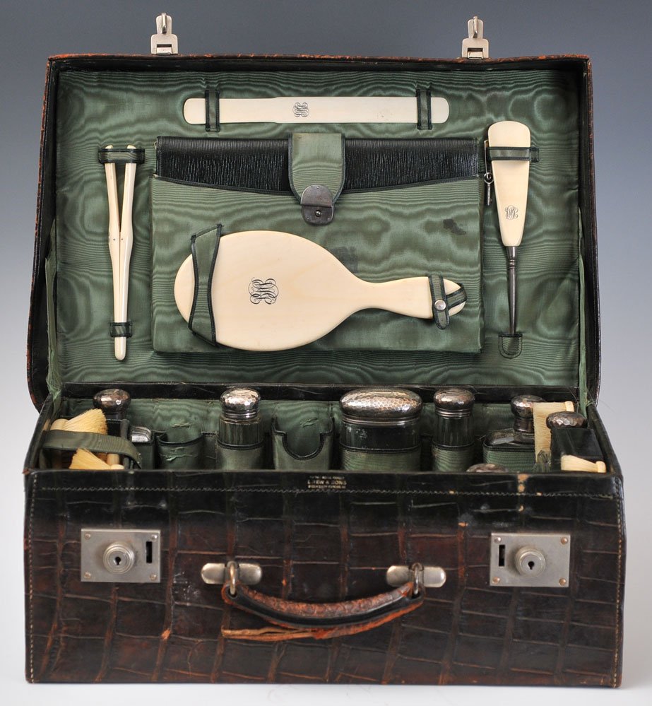 Edwardian Travel Set: Drew & Sons, London the alligator case fitted with 26 matching accessories in sterling and ivory, together with an associated flask (four missing) 20" x 7 1/2" x 14" circa 1890 estimate 800/1200 Shipp