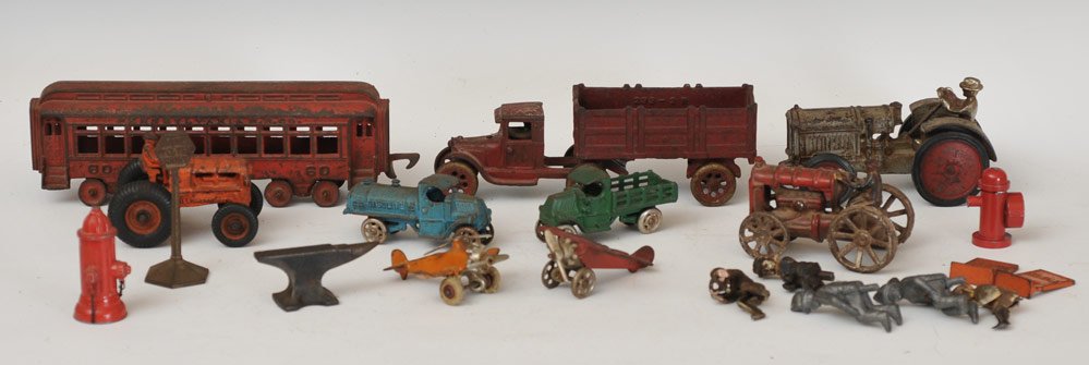 Group of Nine Cast Iron Toys: including green 7 1/4" Arcade McCormic Deering tractor, Orange Arcade 4 3/4" Allis Chambers tractor, 5 1/2" AC Williams Fordsom tractor, PA Railroad Co. 12" Eloise passenger car, three trucks, two air