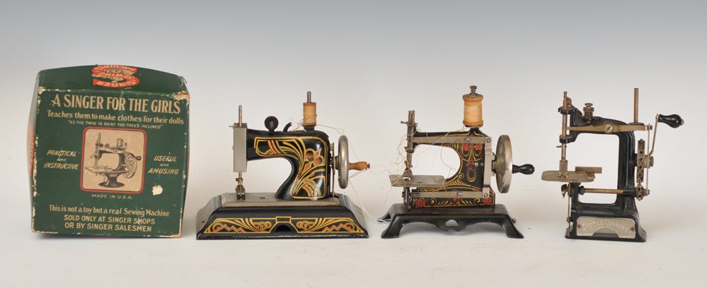 Four Toy Sewing Machines: including Little Comfort nickel and cast iron 6" x 3", 7" high, Boxed Singer nickel and cast iron sewing machine, 7" x 3 3/4", 7" high and two German tin sewing machines