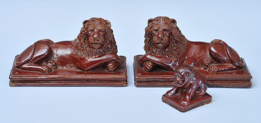 Pair of Glazed Earthenware Lions: each 9 3/4" long dated 1908 together with similar "nobody loves me" pug SHIPPING: Shipping available within the Continental USA (excludes insurance) $40. International buyers are responsible for arran