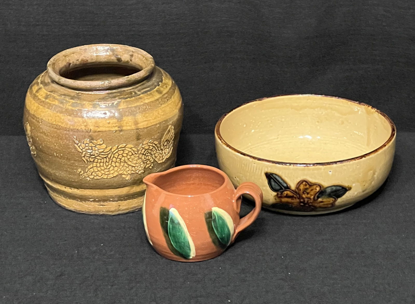 Dragon Stoneware Hand Thrown Pot, Redware Corncob Creamer & Glazed Ceramic Bowl with Flowers: The dragon stoneware hand thrown pot shows some staining but is an attractive piece with bands and color delineation (7" x 7" x 6.5). The corncob creamer is redware and is signed by the artist in 1985