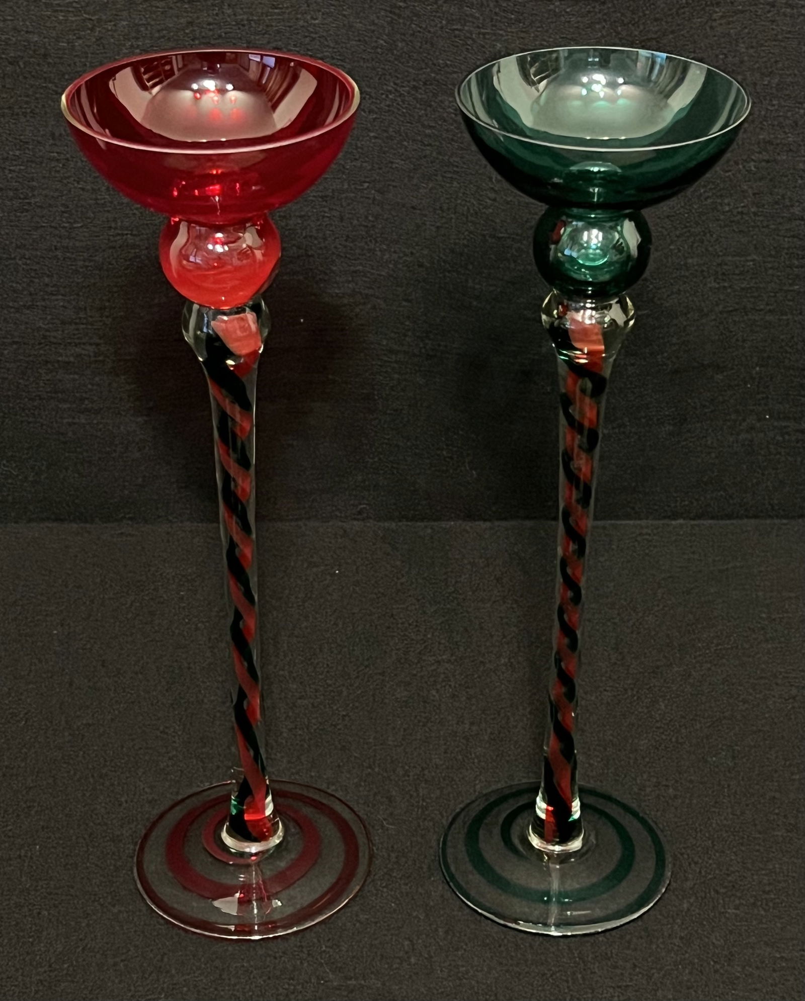 Pair of Tall Glass Holiday Goblets: These striking Holiday goblets (one with a red bowl & the other with a green bowl) are in perfect condition. Their stems are a creative weave of red & green colors. They are stand steady and would rea