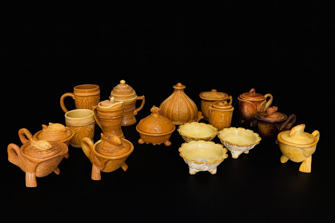 17-Piece Collection of Vintage Caramel Slag & Milk Glass Serveware: Mixed lot of caramel slag and milk glass including swan/fish covered dishes, mugs, urns, compotes, scalloped bowls, and lidded jars. Largest piece approx. 8” H × 7” W