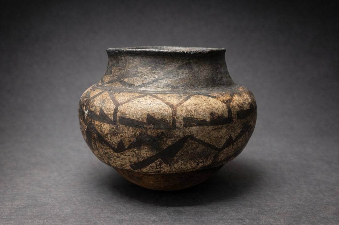 Hand-Built Pottery Vessel w/ Geometric Decoration: Low, bulbous form with short flared rim; earthy brown/black surface with painted geometric banding; visible hand-formed construction and firing variation; interior shows heavy carbon/ash residue from