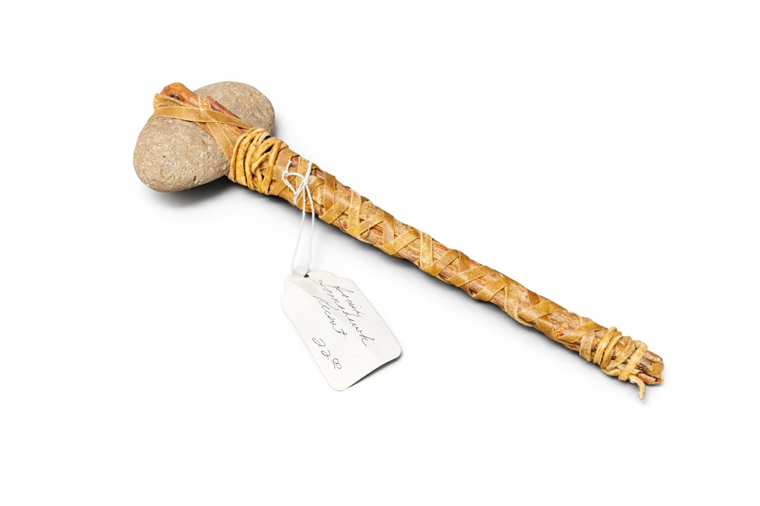 Native American–Style Stone Club / Ceremonial Hammer: hand-crafted example featuring a smooth river stone head secured to a wooden handle with braided rawhide/leather wrapping; rustic, ethnographic appearance with age and patina; likely decorative,