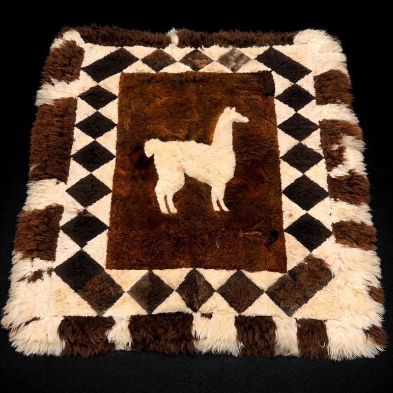 Patchwork Area Rug with Llama Motif: Patchwork Area Rug with Llama Motif – natural sheepskin patchwork rug featuring central white llama figure on brown field with diamond border in cream, brown, and black; approx. 5 ft 9 in L x 4 ft