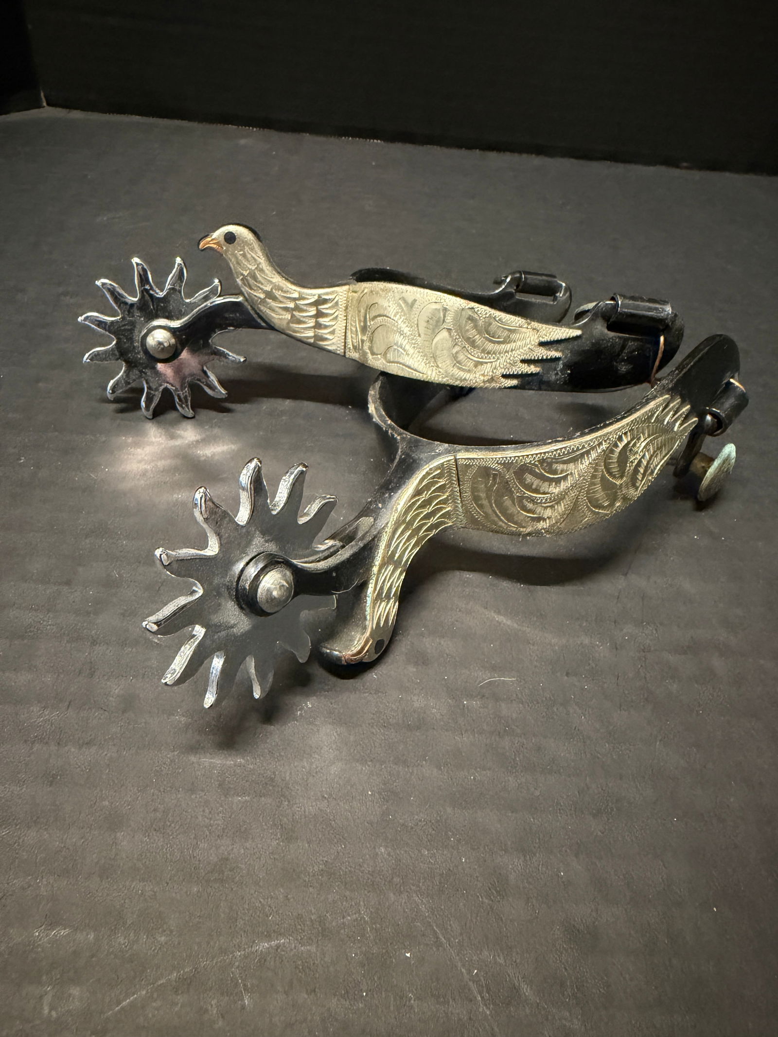Vintage Western Cowboy Spurs, engraved bird motif sterling overlay: Vintage Western Cowboy Spurs, engraved bird motif sterling overlay, blackened steel, marked “Colorado” and “Sterling” (overlay), large sunburst rowels; heel width approx. 3”,