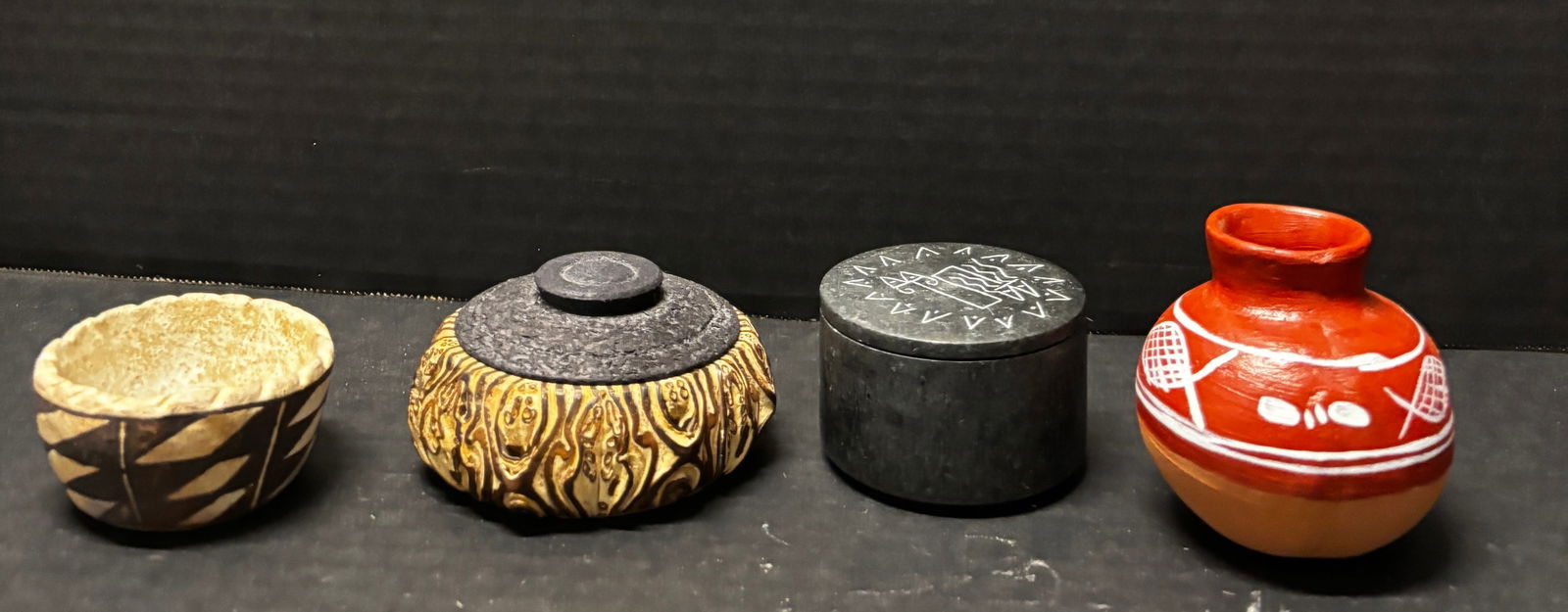 Group of Four Handcrafted Folk / Indigenous-Style Decorative Vessels & Boxes: Including a small hand-carved bowl with geometric decoration, underside marked “ACOMA SKY CITY,” approx. 2.25” H x 3.5” Dia; a lidded carved vessel with raised organic motif and