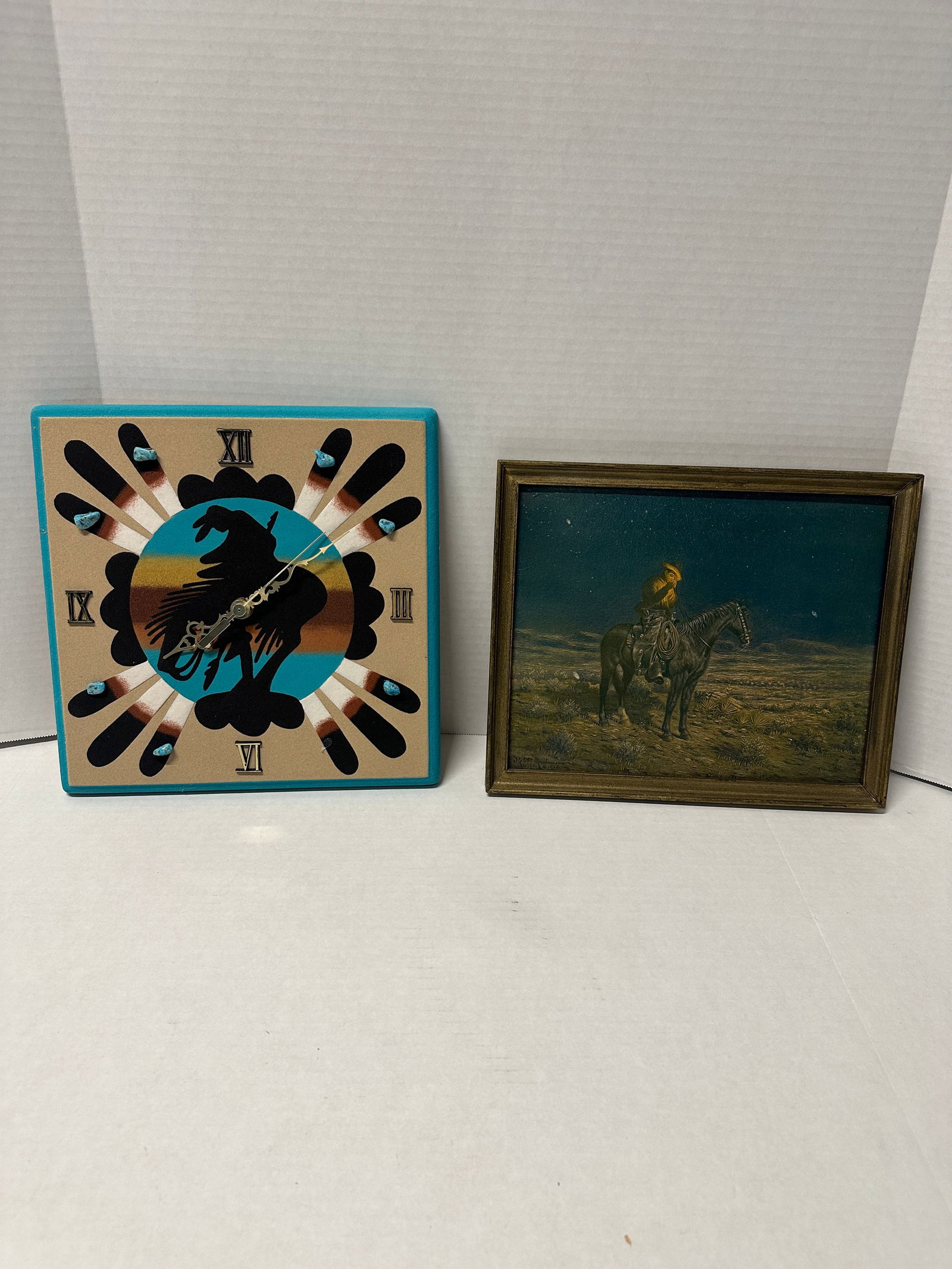SOUTHWEST CLOCK & WESTERN PRINT (2 PCS): Southwestern sand-art wall clock approx 12" x 12" with rider silhouette, Roman numerals and turquoise accents, paired with Western cowboy-on-horse framed print approx 10.5" x 12.5"; both rustic décor