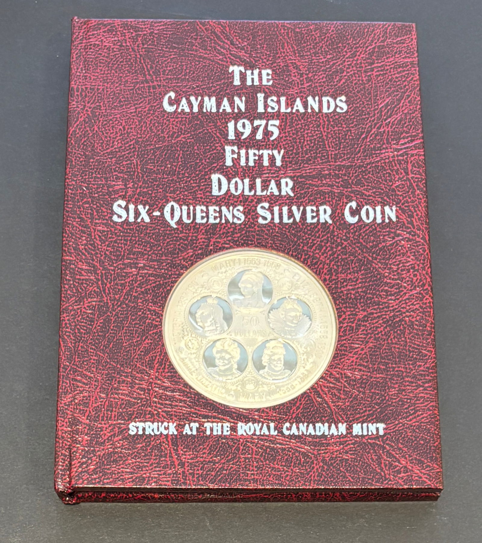 1975 Cayman Islands Fifty Dollar Six-Queens Sterling Silver Proof Coin: 1975 Cayman Islands Fifty Dollar “Six-Queens” commemorative proof coin struck at the Royal Canadian Mint in solid sterling silver. Large 50mm diameter coin weighing 1000 grains (approximately
