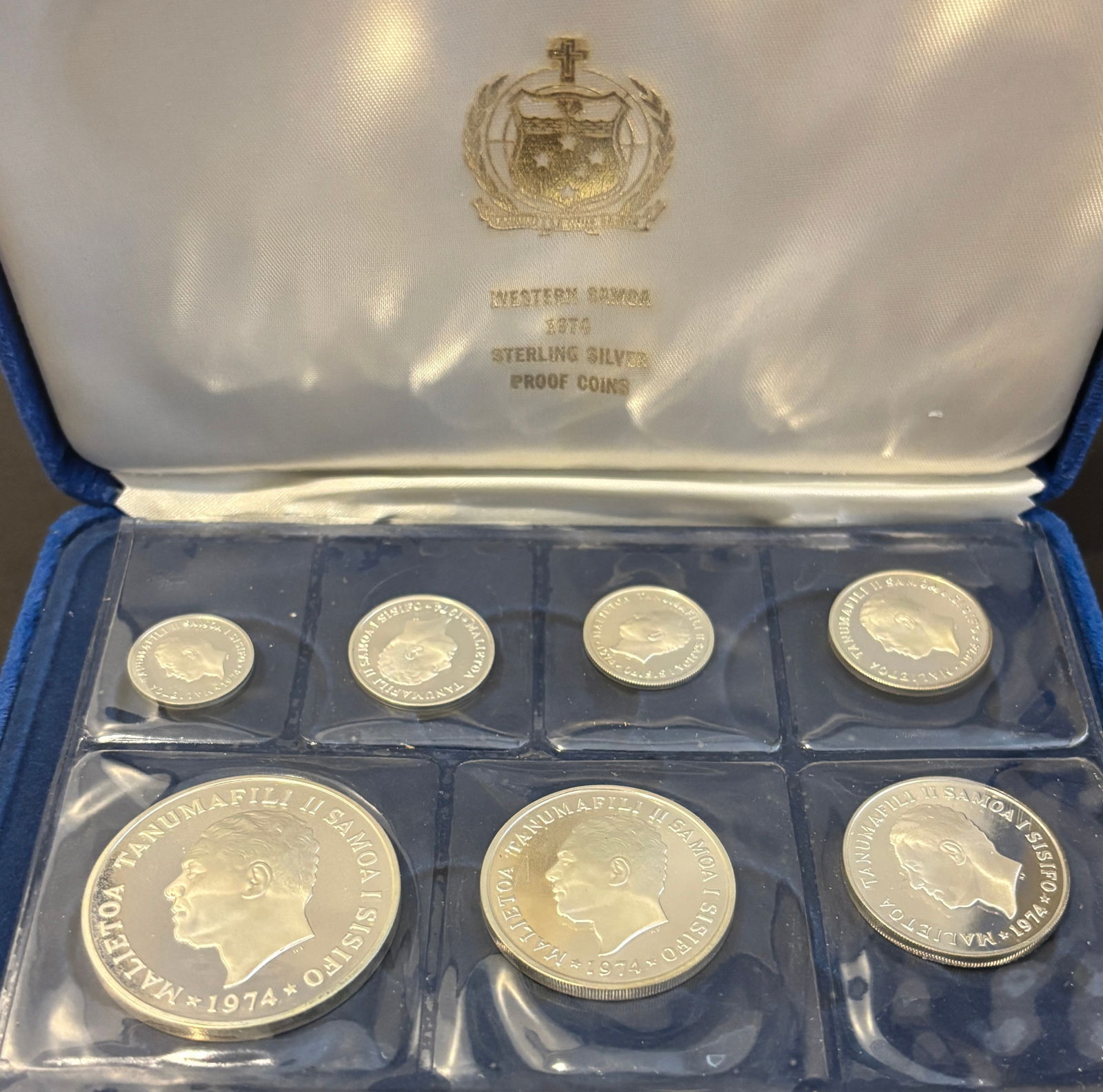 1974 Western Samoa Sterling Silver Proof 7-Coin Set In Original Presentation Case: Official 1974 Western Samoa proof set containing seven coins (1, 2, 5, 10, 20, 50 Sene and $1 Tala) featuring the portrait of Malietoa Tanumafili II on the obverse and native flora/fauna and denominat