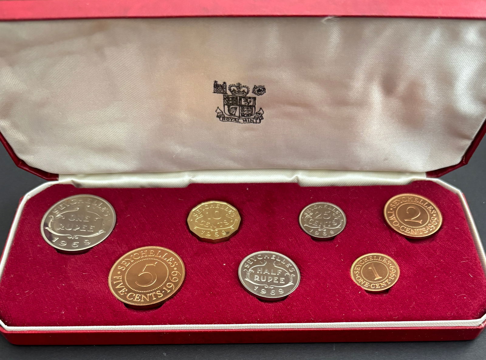 1969 Seychelles Eight-Coin Proof Set Royal Mint: 1969 Seychelles eight-coin proof set issued under authority of the Royal Mint and housed in original red presentation case. Set includes One Rupee, Half Rupee, 50 Cents, 25 Cents, 10 Cents (scalloped)