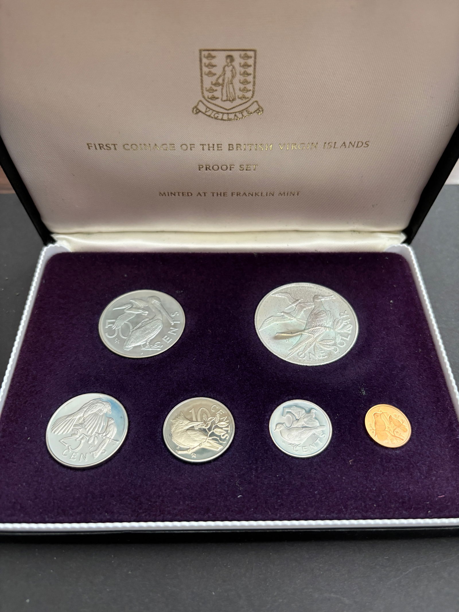 British Virgin Islands First Coinage Franklin Mint Proof Set (7 Coins): First Coinage of the British Virgin Islands proof set struck by the Franklin Mint and housed in the original purple velvet presentation case. Seven-coin set includes $1, 50¢, 25¢, 10¢, 5¢ and 1¢