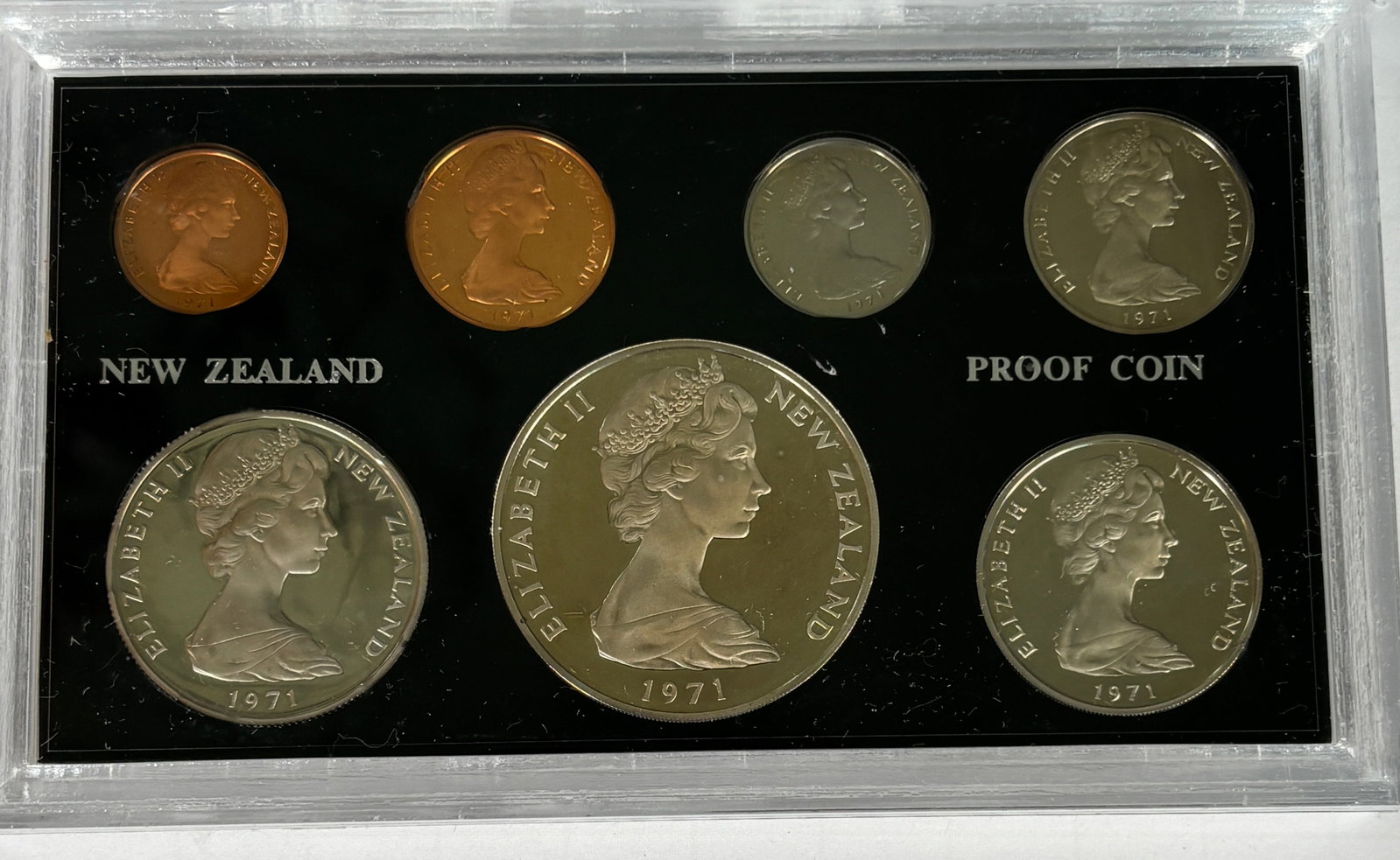 1971 New Zealand Proof Coin Set In Original Case: 1971 New Zealand proof coin set featuring a full denomination run with portrait of Elizabeth II , including multiple coins in mixed metals (silver and bronze issues) presented in original hard case;