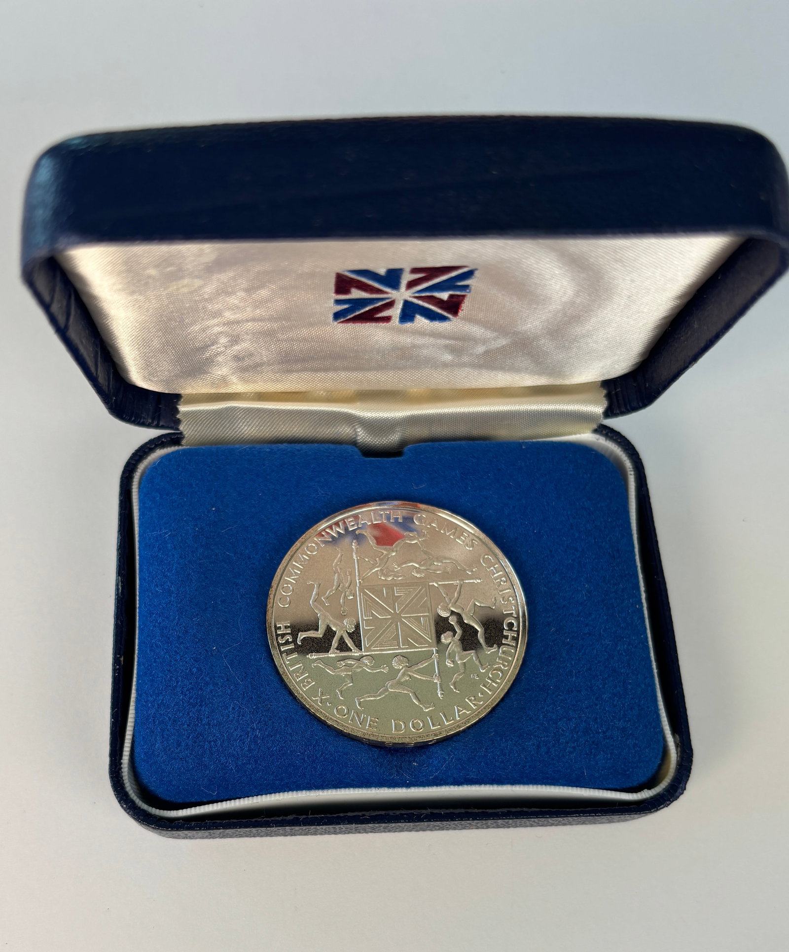 1974 New Zealand Proof Dollar Coin: 1974 New Zealand proof One Dollar coin issued for the 1974 British Commonwealth Games in Christchurch, featuring Queen Elizabeth II on the obverse and a dynamic Commonwealth Games athletic design on t