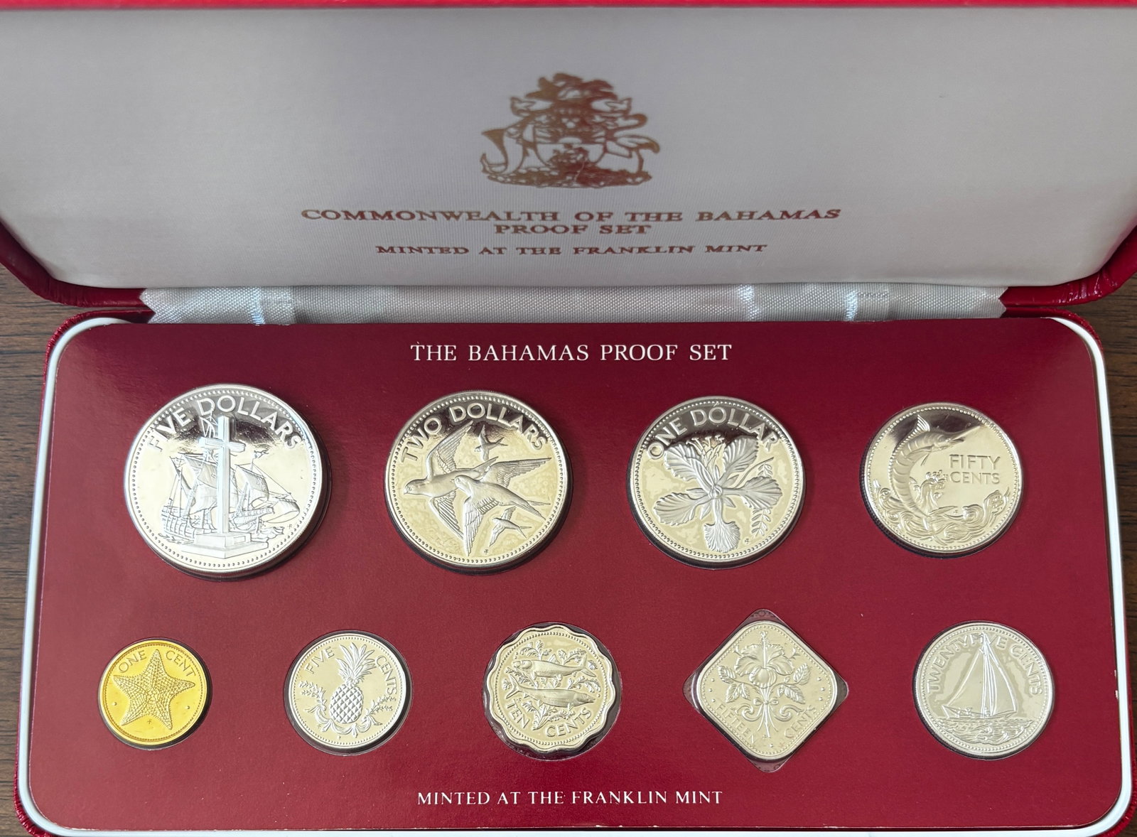 1982 Commonwealth of the Bahamas Proof Coin Set in Original Presentation Case: Official 1982 Commonwealth of the Bahamas Proof Coin Set issued under authorization of the Central Bank of the Bahamas and struck by the Franklin Mint. Housed in its original red presentation case and