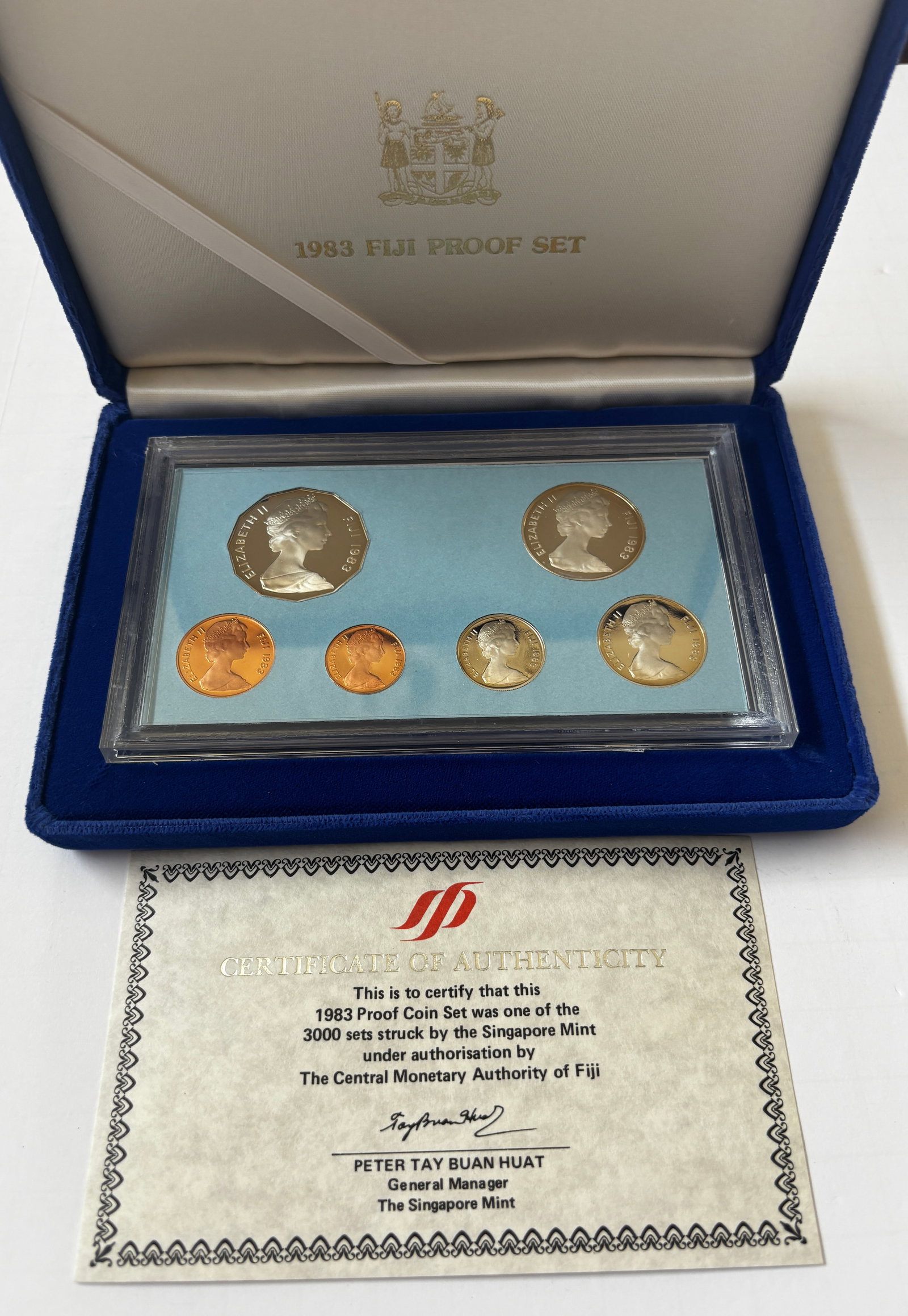 1983 Fiji Proof Coin Set with Case and Certificate: Official 1983 Fiji Proof Coin Set struck by the Singapore Mint under authorization of the Central Monetary Authority of Fiji. Complete six-coin proof set housed in original blue presentation case with
