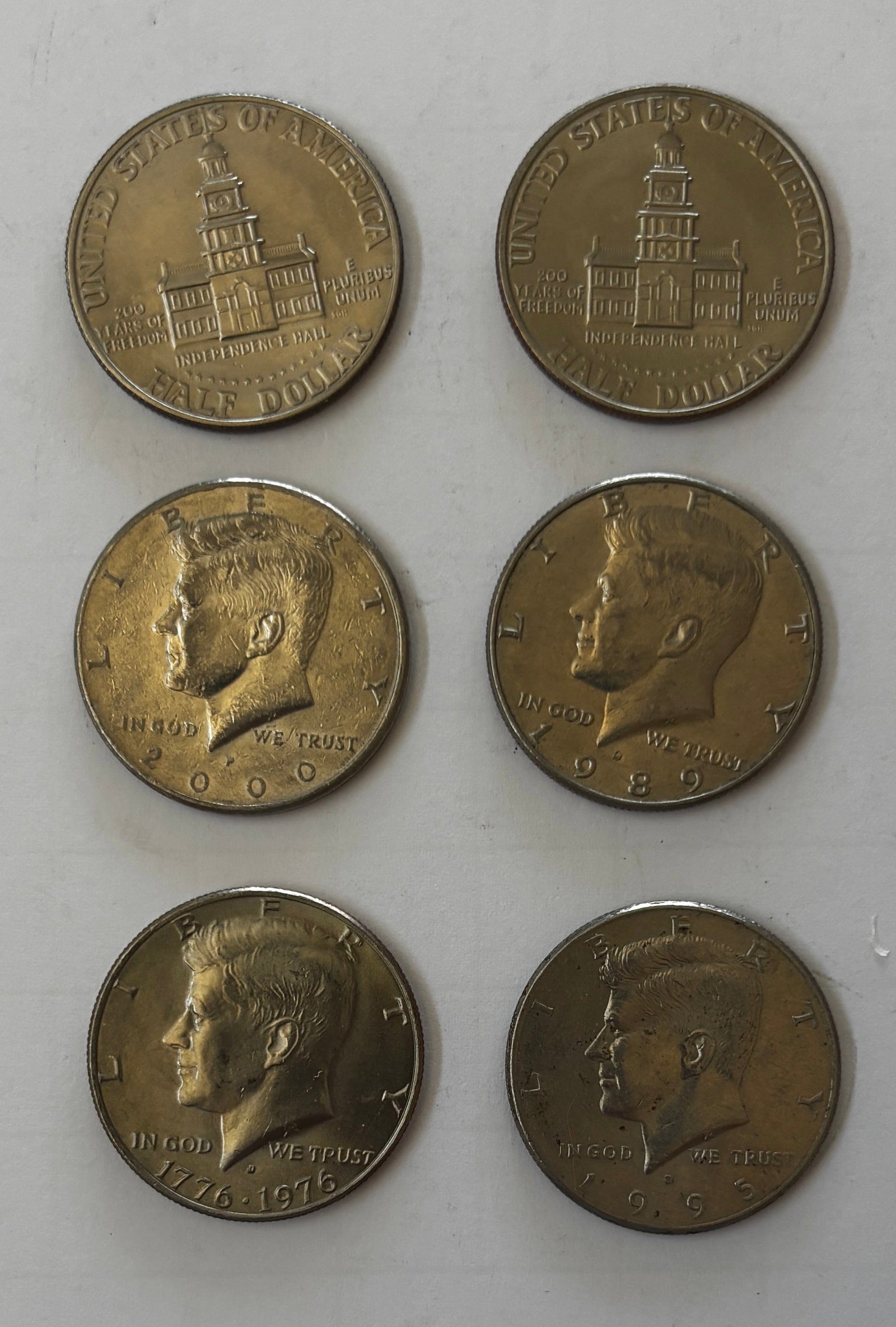 Lot of 16 Kennedy Half Dollars Including Bicentennial Issues: Group of sixteen (16) Kennedy Half Dollars consisting primarily of Bicentennial 1776–1976 issues, together with additional later-date Kennedy half dollars. The lot includes twelve (12) Bicentennial 