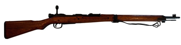 Japanese Arisaka Type 38 Bolt Action Rifle 6.5x50mm: Japanese Arisaka Type 38 bolt-action rifle, chambered in 6.5x50mm Arisaka, with blued steel barrel and receiver, full-length walnut stock, and military configuration including front sight assembly and