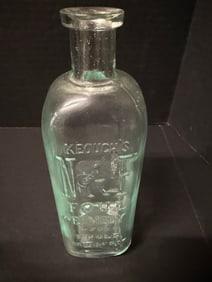 KEOUGH’S NF Foul Remedy Embossed Aqua Medicine Bottle w/ Mortar & Pestle Graphic 7in St Louis: Embossed KEOUGH’S NF FOUL REMEDY aqua patent/veterinary medicine bottle with mortar & pestle graphic, St Louis MO origin, applied lip, approximately 7in high