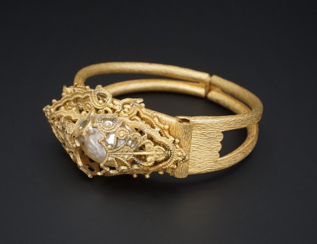 Miriam Haskell Faux Pearl Cuff Bracelet Gold Tone Hinged 6.5" Vintage BS2709: Description: This vintage bracelet is crafted of gold tone metal featuring a pearl concealed by ornate panels. Highly collectable and great worn on its own or added to your favorite stack! Metal Type: