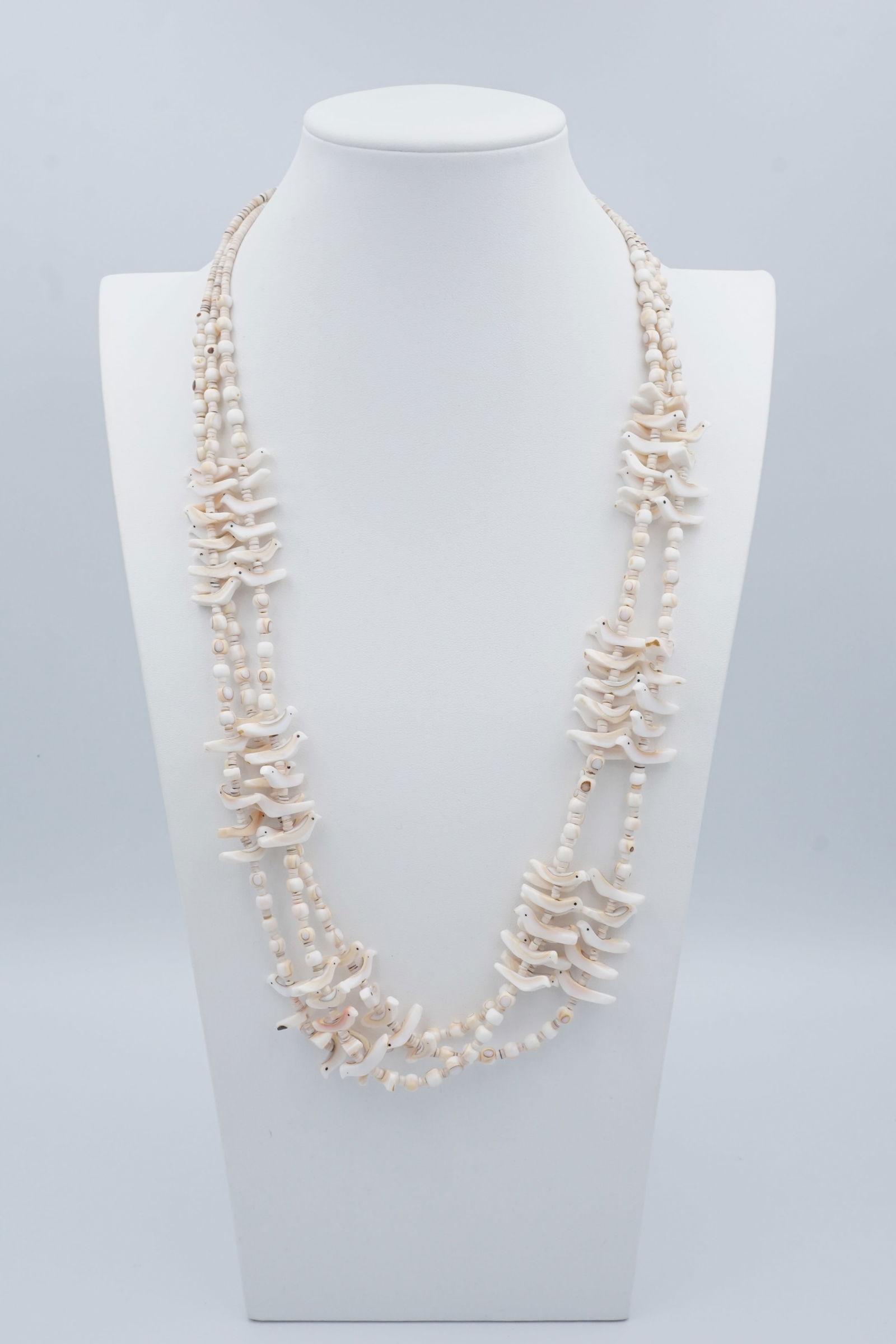 Vintage Coral Navajo Birds Strands Necklace: A beautiful three-strand Navajo necklace in white and pink coral, composed of beads and carved birds, with a silver clasp. Measurements: L 28 inches Condition: Very good. Jewelry Items Disclosure All