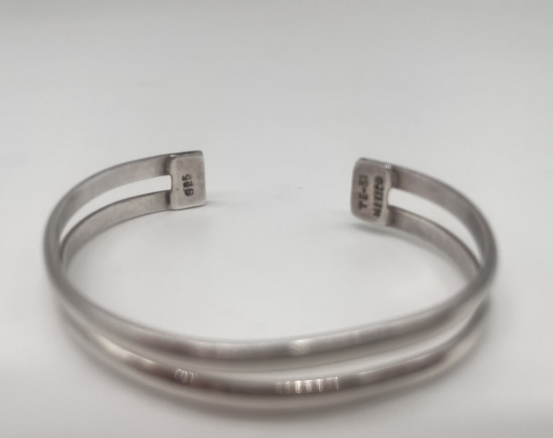 Sterling Silver Mexico Double Bar Cuff Bracelet: An elegant sterling silver double cuff bracelet, perfect for stacking or wearing alone. Metal Type: Sterling SilverNotable Marks: 925 Mexico TE-51Measurements: Diameter 2.5 in, height 0.4 inWeight: 18