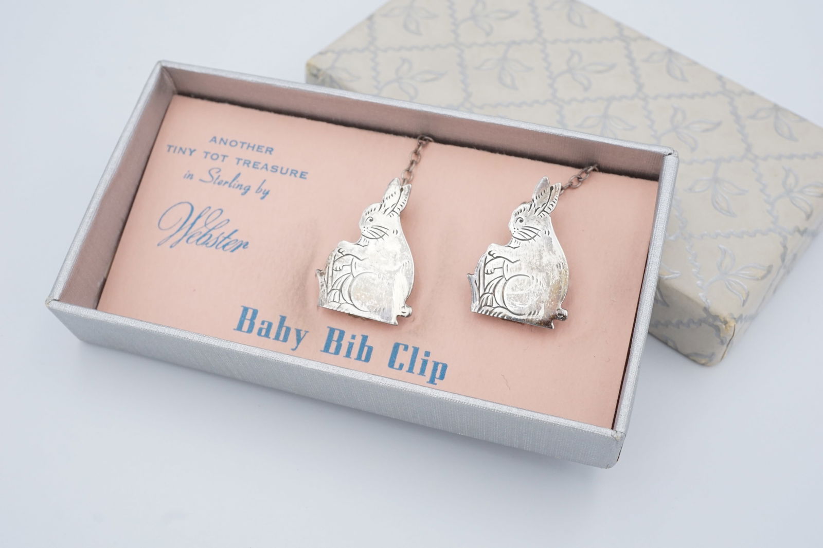Vintage Webster Baby Bib Clips: Popular in the 30s and 40s, these precious Webster baby bib clips in sterling silver make the perfect christening gift. The clips are decorated in bunny shapes, held together by a simple chain. Metal