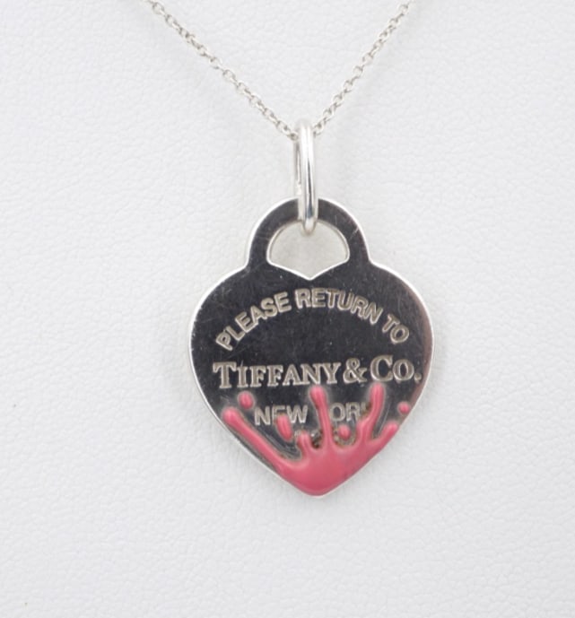 Tiffany Pink Splash Heart Tag Necklace Sterling Silver 16" 1.1mm Retired NS2289: This retired Tiffany & Co. necklace features the iconic heart tag etched with the phrase "Please Return to Tiffany & Co." crafted of solid sterling silver with a pink enamel splash design at the base.