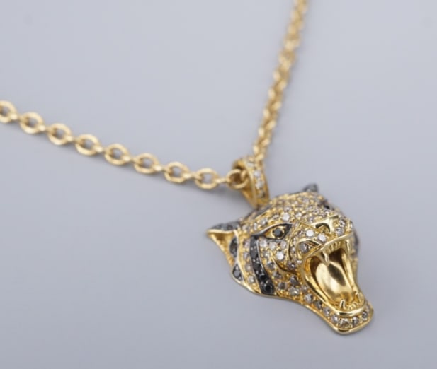 Roberto Coin Animalier Diamond Necklace Tiger 18k Rose Gold 20" NG1784: A striking designer piece by Roberto Coin, this bold tiger head pendant necklace is finely crafted in 18k yellow gold. The pendant is set with sparkling round brilliant-cut diamonds accented by black