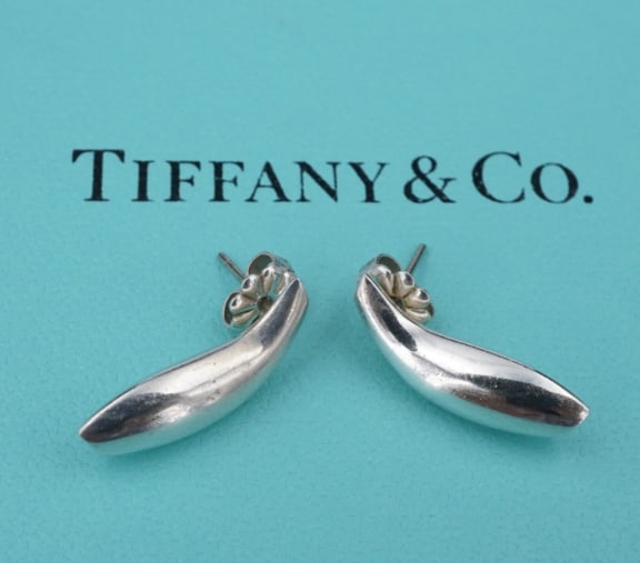Tiffany & Co. Sterling Silver Earrings Curved Fish Stud Frank Gehry ES2458: These beautiful earrings are designed by iconic Tiffany & Co artist Frank Gehry. Featuring a curved design, these fluid earrings are a fun and elegant design. Metal Type:Sterling Silver (marked and te
