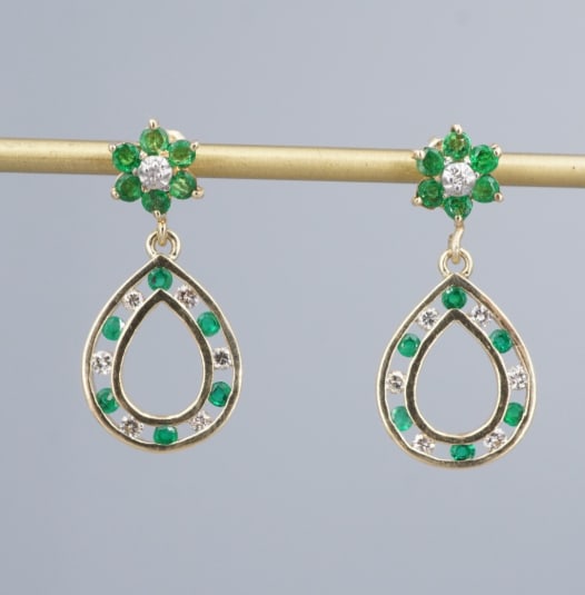 14k Emerald Diamond Dangle Earrings Yellow Gold Natural 1" 1 ctw Flower EG2749: This beautiful pair of yellow gold earrings features a beautiful and classic combination of natural diamonds and green emeralds, arranged in a floral stud with an open teardrop frame dangling beneath.