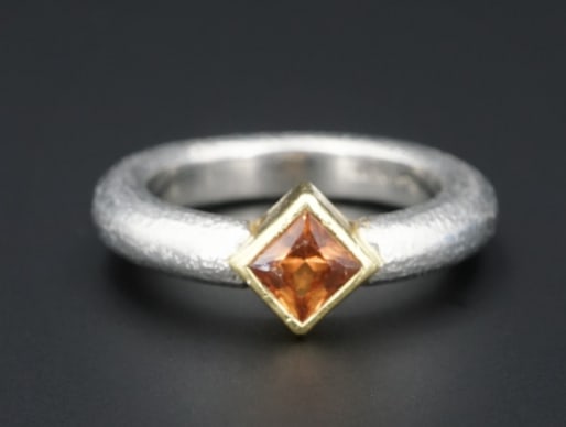 Matthew Trent Platinum 18k Gold Orange Sapphire "Donut" Ring Size 5.25 RG3513: This modern designer Matthew Trent ring from the "Donut" collection features a brown-orange sapphire gemstone bezel set in luxe 18k yellow gold atop a bold platinum band with a textured finish. An all