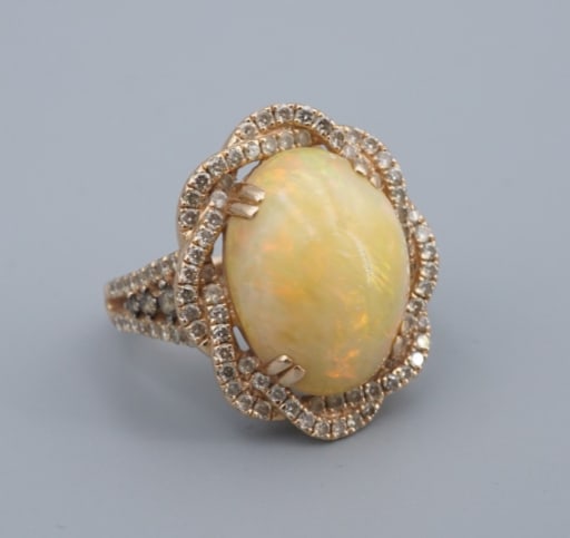 Levian 14k Yellow Gold Diamond Opal Cabochon Cocktail Ring Size 5.75 RG4928: This amazing ring from LeVian features a natural opal center stone shimmering with bright oranges and greens, providing a beautiful contrast with the unique twisted diamond halo. Additional diamond an