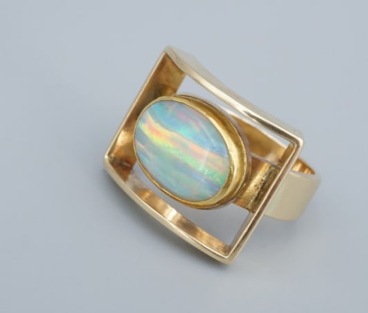 Henry Steig Modernist Opal Cocktail Ring 14k Yellow Gold Size 7 Vintage RG5012: This beautiful modernist ring from designer Henry Steig features a large, natural opal cabochon bezel set atop a wide 14k yellow gold band. The opal is surrounded by a large rectangular frame, adding