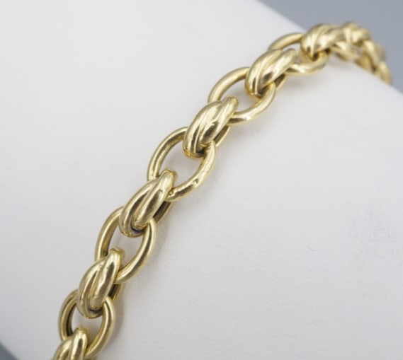 Roberto Coin Cable Bracelet 18k Yellow Gold Interlocking Oval 7" 7mm 18g BG1088: This authentic Roberto Coin bracelet is crafted of rich 18K yellow gold oval links each joined to the next by an interlocking twist. Polished and dimensional, this adds the perfect touch of everyday e
