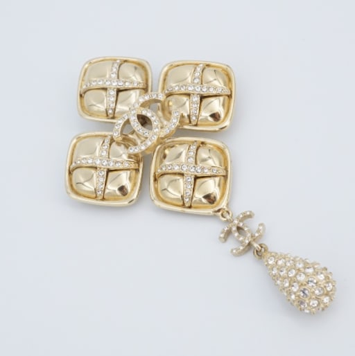 Chanel F21 CC Brooch in Gold-Tone with Crystals France Couture Designer OS687: From the F21 collection, this classic Chanel CC brooch features a large quad of squared buttons each adorned with a crystal X. The classic CC logo sparkles from the center as well as dangling below wi