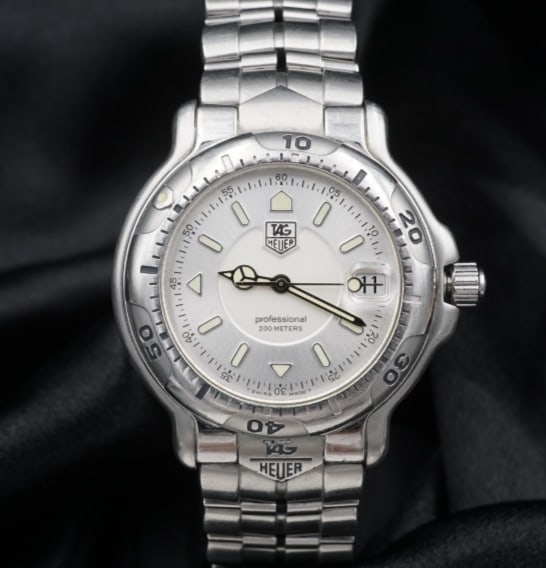 TAG Heuer 6000 Series Professional WH1113 Quartz Men's Watch 38mm W1271: The TAG Heuer Series 6000, model WF-1113 features a stainless steel case and band, a silver dial with baton markers, date and quartz movement. An amazing watch for those who appreciate a bold and mode