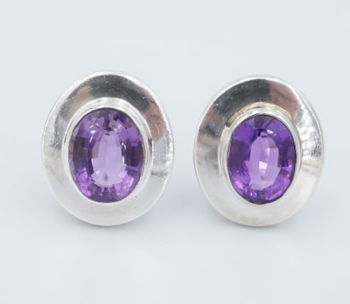 Burle Marx Earrings Sterling Silver Amethyst Clip-On Natural 1" Vintage ES2790: These beautiful clip-on earrings from designer Burle Marx each feature a vivid oval-cut amethyst gemstone bezel-set in an ovular frame crafted in solid sterling silver. These earrings are a beautiful 