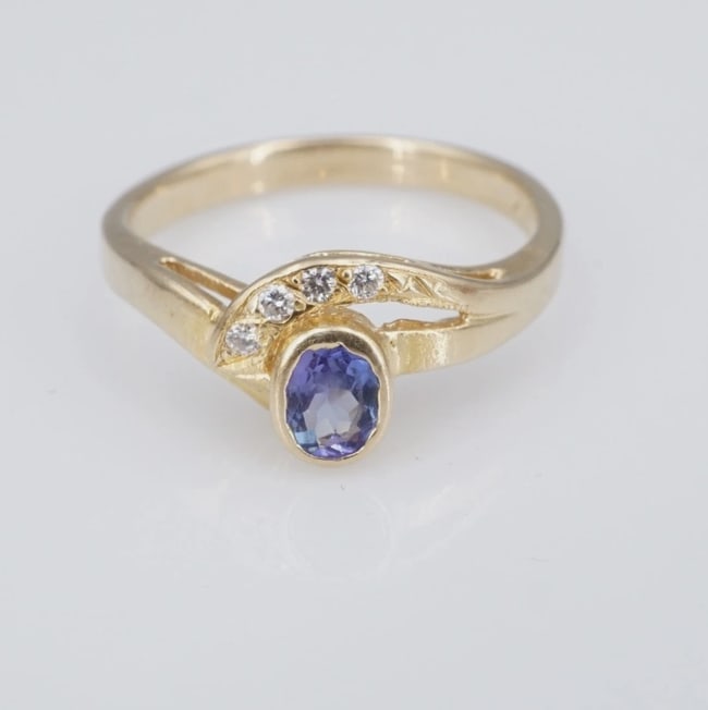 14k Tanzanite Diamond Cocktail Ring Yellow Gold Natural Size 8 RG4927: This beautiful ring features a stunning oval-cut tanzanite bezel set atop a slim 10k yellow gold bypass design embellished with a swirl of natural round diamonds. The yellow gold provides a complement