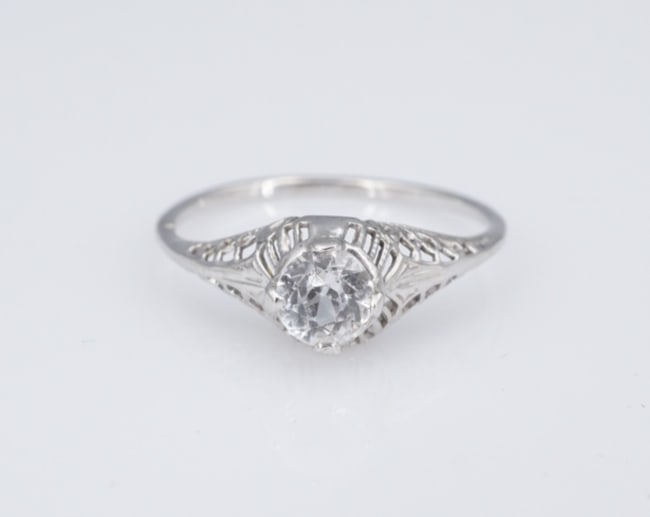 Antique 14k Solitaire Sapphire Promise Ring White Gold Filigree Size 7 RG4937: This beautiful antique ring features a white sapphire set in a elegant domed mount with gorgeous filigree details. The slim band provides a delicate comfortable fit. This would be a perfect engagement