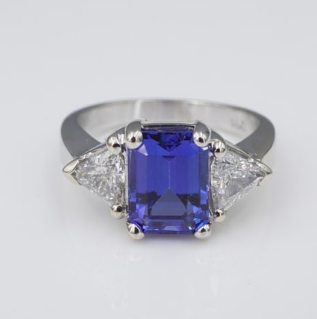Tanzanite Diamond Cocktail Ring 14k White Gold 3-Stone 3 carBand Size 6 RG4077: This beautiful ring centers on a 2.2 carat deep purple, emerald cut tanzanite gemstone flanked by natural diamond trillions prong set atop a polished 14k white gold band. The vivid tanzanite and white